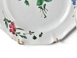 two plates with flowers painted on them on a white surface