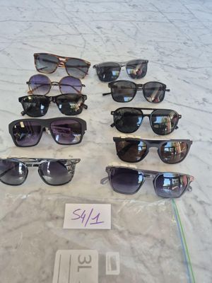 many pairs of sunglasses sitting on a table with a price tag