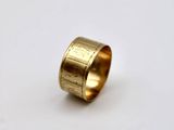 a close up of a gold ring on a white surface