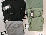 trois paires de pantalons et un sac à dos posés sur une table