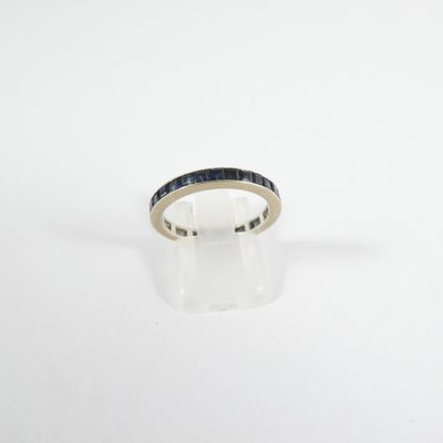 a gold ring with blue sapphires on a white background