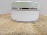 a jar of cream sitting on a wooden table