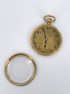 a gold pocket watch and a magnifying glass on a white surface