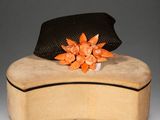a hat sitting on top of a box with a flower on it