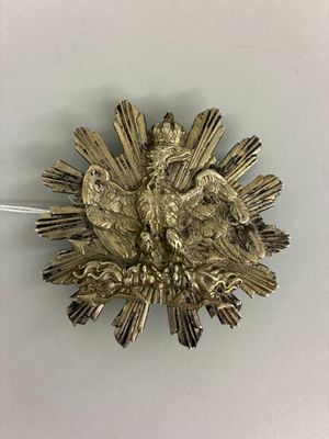 une broche en argent surmontée d'un oiseau
