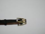 a close up of a belt with a metal buckle on a white surface