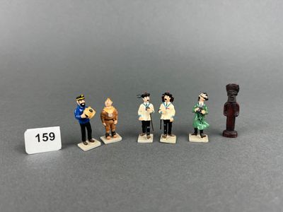 five figurines of people in different outfits are posed next to a price tag