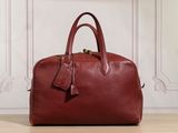 un sac à main en cuir rouge posé sur un parquet