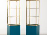 une paire de vitrines bleues et dorées dans une pièce blanche