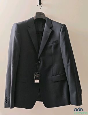 a suit hanging on a hanger on a wall