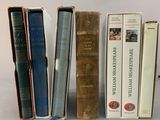 several books are lined up in a row on a white surface