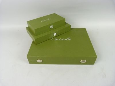 two green boxes are stacked on top of each other on a white surface