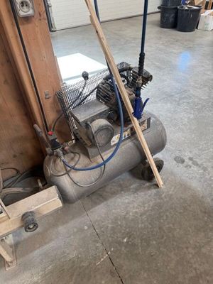 un petit compresseur d'air posé dans un garage
