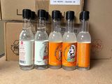 quatre bouteilles d'alcool posées sur une table à côté d'un carton