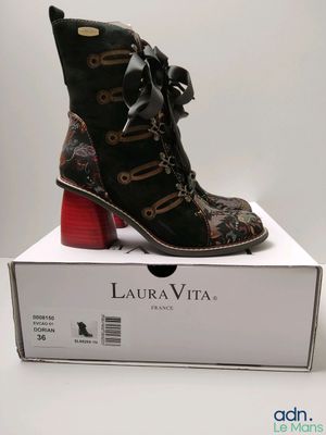 la boîte est ouverte et laisse apparaître une paire de bottes noires