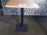 une petite table sur laquelle est posé un panneau, devant un mur