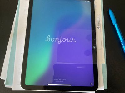 a tablet with the word bonjou on it and a pen next to it