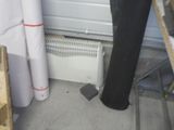un tuyau noir dans un coin de la pièce, près d'un mur