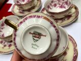 a person holding a cup and saucer on a table