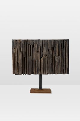 a close up of a wooden lamp on a metal stand