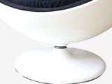 a white chair with a black cushion on top of it