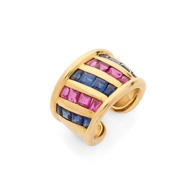 un gros plan d'une bague en or sertie de pierres roses et bleues