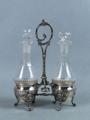 two glass vases sitting on top of a metal stand