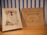 two old books on a table next to a blue and white striped wall