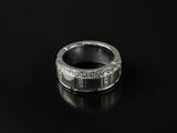 a close up of a silver ring on a black surface