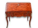 un petit bureau en bois avec des tiroirs, surmonté d'autres tiroirs
