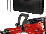une image représentant un marteau-piqueur électrique rouge dans lequel est inséré un outil