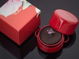 une boîte rouge contenant un anneau, posée sur une surface noire