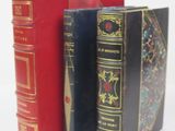 three books sitting next to each other on a white surface