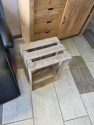 une caisse en bois posée par terre à côté d'une chaise noire