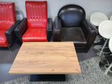 several chairs and a table in a room with red and black leather chairs