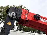 a red crane that is sitting in front of a truck