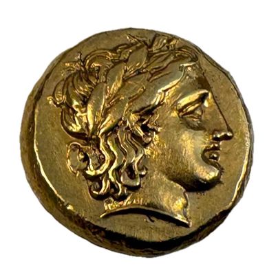 gros plan d'une pièce d'or portant un visage de femme