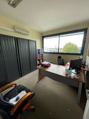 un bureau avec un ordinateur et une chaise dans une pièce