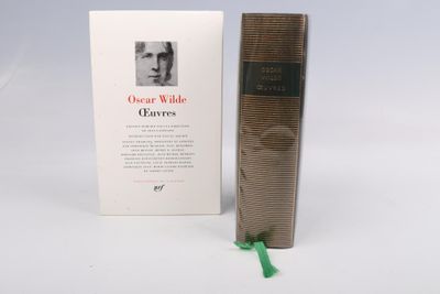 un vieux livre, avec un ruban vert à côté, posé sur une surface blanche