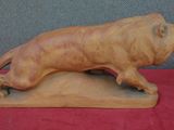statue d'un lion posé sur un rocher, sur un tissu rouge