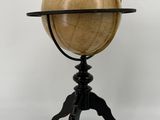 an antique globe on a tripod with a wooden stand