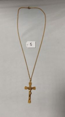 un collier en or orné d'une croix et d'une plaque