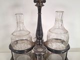 three glass bottles and a metal holder on a table