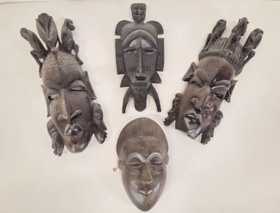 Plusieurs masques africains sont exposés sur un fond blanc