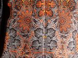 an orange and black shirt with a floral design on it