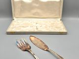two forks and two spoons sitting next to a case