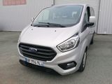 l'avant d'une camionnette argentée garée devant un immeuble