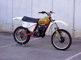 a dirt bike parked in a parking lot next to a wall