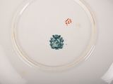 a white plate with a green flower on it
