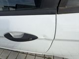 a white car with a black door handle on the side of the road